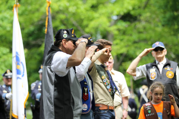 2015年5月24日(火)、米国maのレキシントンで行われた記念日の式典で敬礼する退役軍人とスカウト - child military saluting flag ストックフォトと画像
