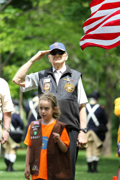 2015年5月24日(火)、米国フロリダ州レキシントンで開催された記念日セレモニーで敬礼するアメリカ海軍退役軍人 - veteran senior adult saluting armed forces ストックフォトと画像