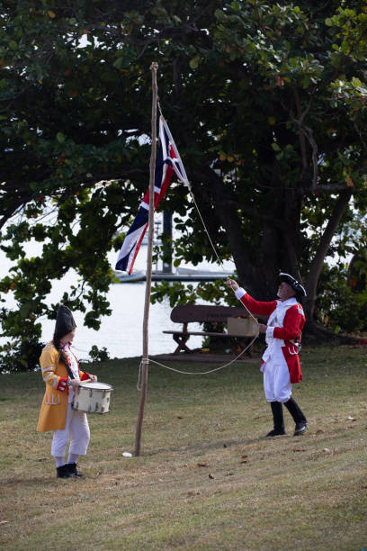 alzando bandiera britannica in australia durante la rievocazione dello sbarco del tenente james cook a waalmbal birri (fiume endeavour) e incontri con il guugu yimithirr bama nel 1770. il 250 ° anniversario del primo contatto dell'australia, cooktown, que - indigenous culture australia aborigine australian culture foto e immagini stock