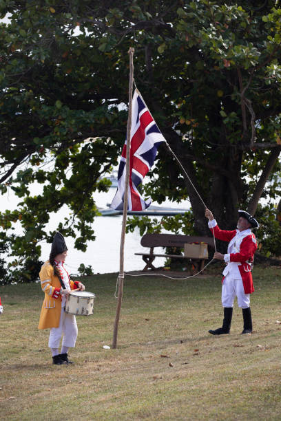 alzando bandiera britannica in australia durante la rievocazione dello sbarco del tenente james cook a waalmbal birri (fiume endeavour) e incontri con il guugu yimithirr bama nel 1770. il 250 ° anniversario del primo contatto dell'australia, cooktown, que - indigenous culture australia aborigine australian culture foto e immagini stock