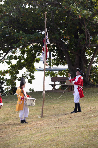 alzando bandiera britannica in australia durante la rievocazione dello sbarco del tenente james cook a waalmbal birri (fiume endeavour) e incontri con il guugu yimithirr bama nel 1770. il 250 ° anniversario del primo contatto dell'australia, cooktown, que - indigenous culture australia aborigine australian culture foto e immagini stock