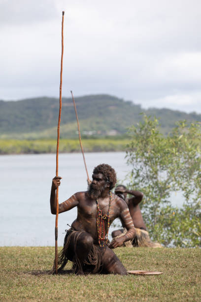 les aborigènes australiens en tenue autochtone se produisent lors d’une reconstitution historique de caaalmbal birri (endeavour river) et rencontrent le guugu yimithirr bama en 1770. the 250th anniversay of australia’s first contact, cooktown, queensl - aborigine indigenous culture australian culture australia photos et images de collection