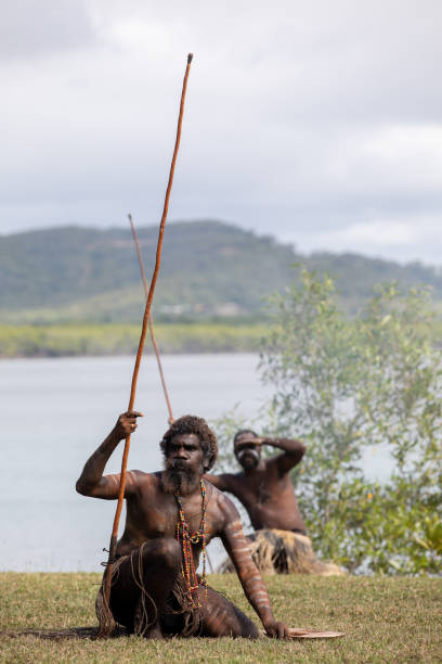 les aborigènes australiens en tenue autochtone se produisent lors d’une reconstitution historique de caaalmbal birri (endeavour river) et rencontrent le guugu yimithirr bama en 1770. the 250th anniversay of australia’s first contact, cooktown, queensl - aborigine indigenous culture australian culture australia photos et images de collection