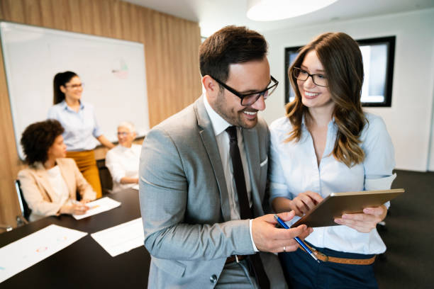 istock Happy business colleagues in modern office using tablet 1323330262