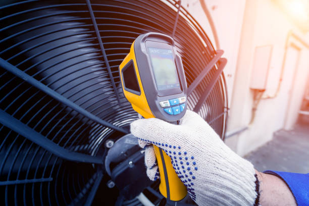 istock Technician uses a thermal imaging infrared thermometer to check the condensing unit heat exchanger. 1323336607