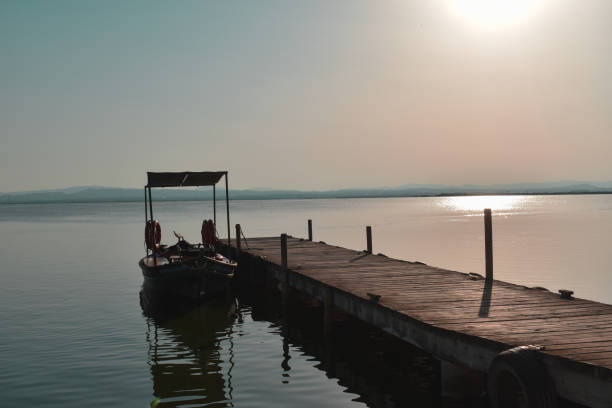istock Jetty with a boat on a large lake 1323336696