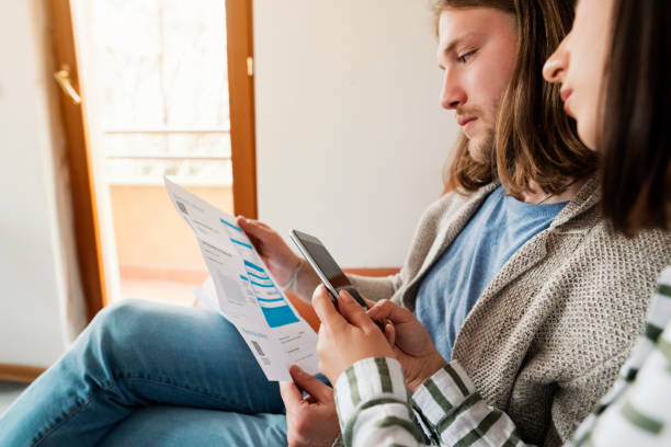 istock Young couple scanning the QR code with a phone and paying the bill 1323342810