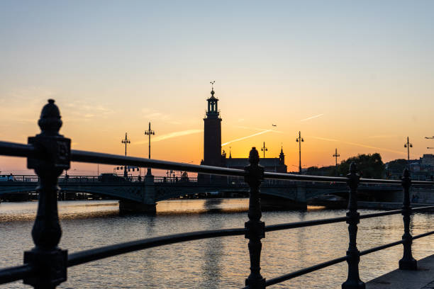 Beautiful view of the Stockholm City Hall during sunrise. Contrasting dark silhouette against the orange sky. Stockholm, Sweden