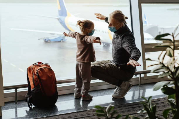 istock Father and child looking though lounge window at airport 1323347940