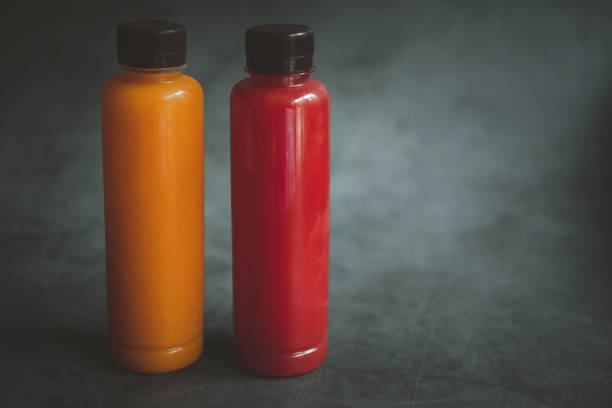 istock Watermelon and orange juice in plastic bottle on a black background. 1323348042