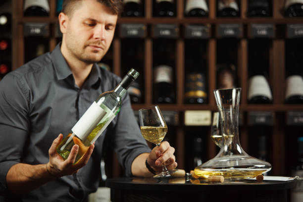 istock Sommelier pouring white wine from bottle in glass 1323349423