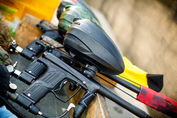 three paintball markers stand in a row three paintball markers with air balloons stand in a row on a board paintballing stock pictures, royalty-free photos & images