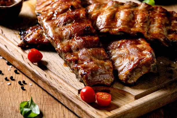 istock Grilled pork bbq ribs served with cherry tomatoes 1323356017