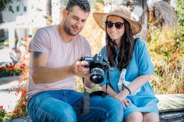 istock Friends sitting together looking photos from dslr camera 1323357995