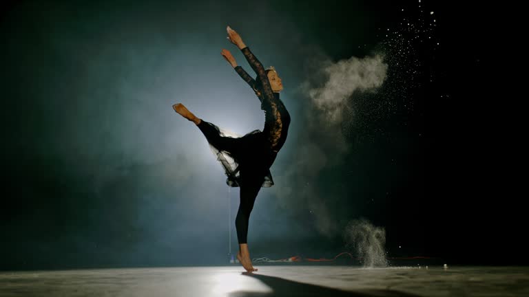 SUPER SLO MO Professional ballerina throws the dust out of her hand while spinning on the stage