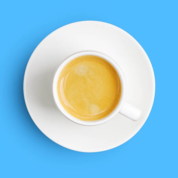 istock Closeup white cup of coffee espresso isolated on blue with shadow. Top view. 1323359108