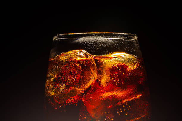 macro cola glass,a cool glass of cola drink with ice, bubbles and fizz - drink ice splashing spray imagens e fotografias de stock