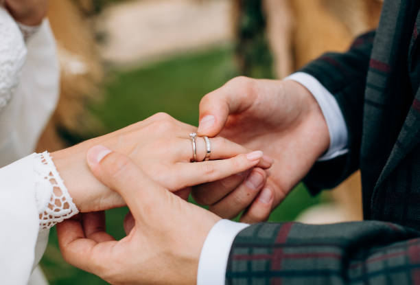 istock groom plaid suit puts ring bride hand 1323365413