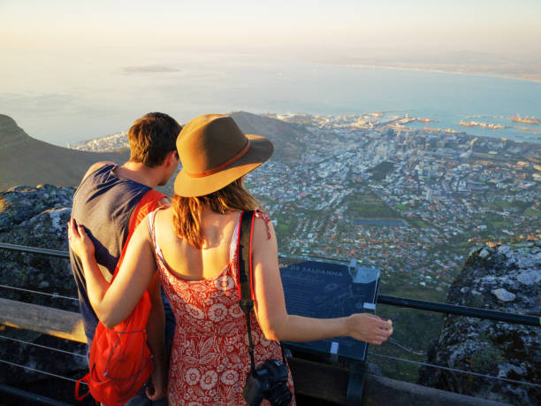 Rear view of young couple of tourists looking at Cape town from the top of Table Mountain Rear view of young couple of tourists looking at Cape town from the top of Table Mountain southern africa stock pictures, royalty-free photos & images