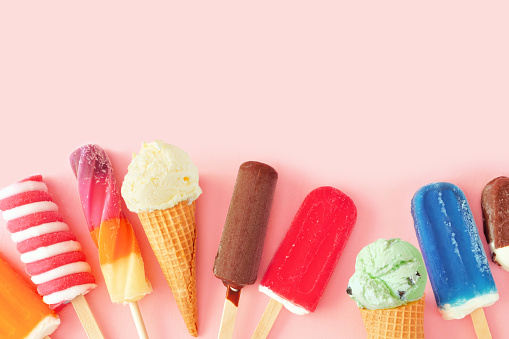 Collection of colorful summer frozen desserts, bottom border on a pink background