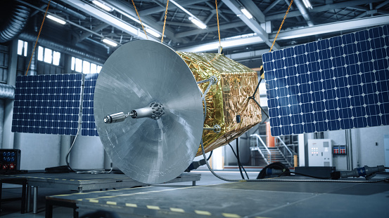 Satellite Under Construction in Aerospace Technology Manufacturing Facility. Development of Spacecraft for Space Exploration, Navigation, Communications, Internet Telecommunication, Observation