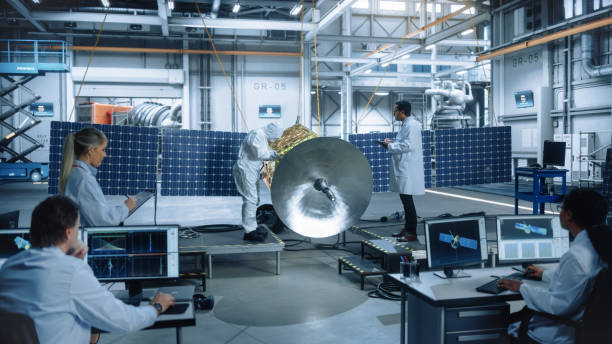 istock Team of Engineers Working on Satellite Construction. Aerospace Agency Spaceship Manufacturing Factory: Diverse Group of Multi-Ethnic Scientists Developing Spacecraft for International Space Program 1323369493