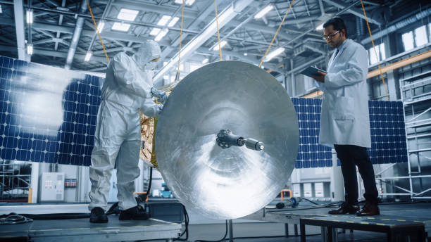 istock Engineer and Technician Working on Satellite Construction. Aerospace Agency Spaceship Manufacturing Factory: Diverse Group of Scientists Developing Spacecraft for Space Exploration Program 1323369502
