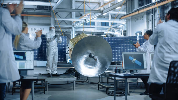 istock Technician in Protective Suit Finishes Satellite Construction, Team of Scientists Applaud and Cheer for Successful. Aerospace Agency Manufacturing Facility: Scientists Assembling Spacecraft. 1323369574