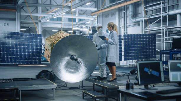 Female Chief Engineer talk to Technician while he is Working on Satellite Construction. Aerospace Agency Manufacturing Facility: Scientists Build, Assemble Spacecraft for Space Exploration Mission la ingeniera jefe habla con el técnico mientras está trabajando en la construcción de satélites. instalación de fabricación de la agencia aeroespacial: los científicos construyen y ensamblan naves espaciales para la misión de exploración espacial