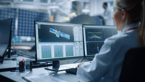 la ingeniera utiliza la computadora para analizar el satélite, calcular el seguimiento de la trayectoria orbital. aerospace agency international space mission: scientists working on spacecraft construction. sobre el hombro - aerospace industry fotografías e imágenes de stock