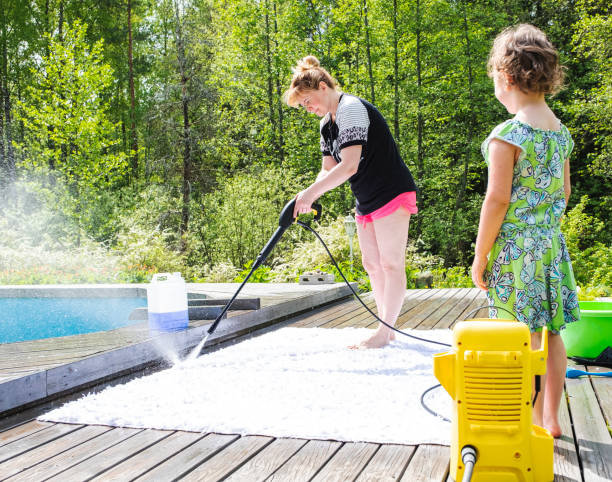 Mom and daughter wash carpets on a wooden terrace in the backyard of the house. The child girl is happy to help her mother. Mom and daughter wash carpets on a wooden terrace in the backyard of the house. The child girl is happy to help her mother. vacation rental cleaning stock pictures, royalty-free photos & images