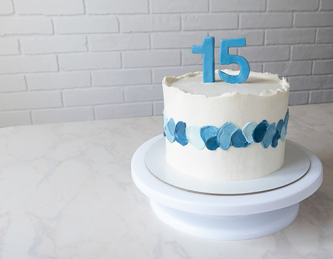 birthday cake with figures of 15. cake with blue decor and a copy space.