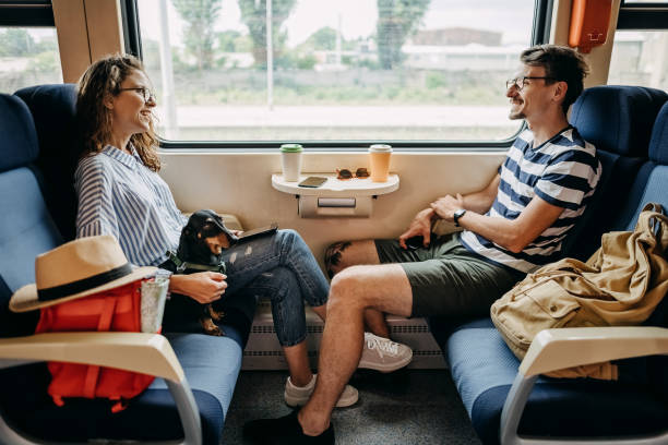 Young couple on a train with a dog Young couple travels by train with their dog travel destinations 20s adult adventure stock pictures, royalty-free photos & images
