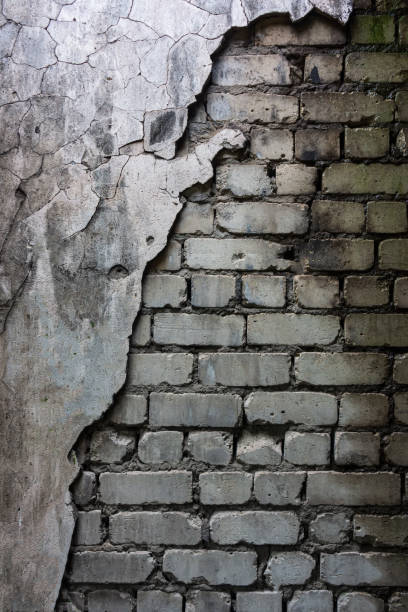 istock wet brick wall and crumbling cement plaster. 1323373025