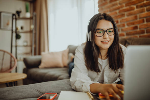 istock A young female student sitting on thek couch using laptop headphones when studying 1323374457