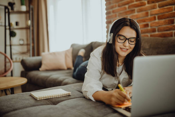 istock A young female student sitting on thek couch using laptop headphones when studying 1323374471