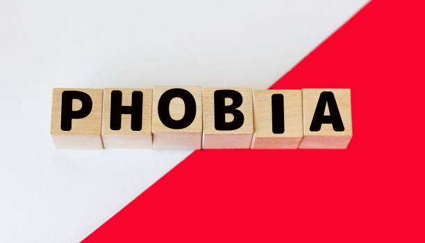 istock Wooden blocks with the text: Phobia on a white and red background 1323381806
