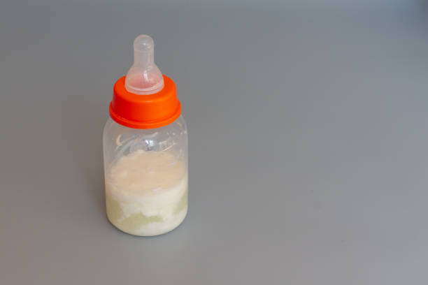 istock A bottle with a pacifier for feeding a baby with sour milk on a gray background. copy space 1323382726