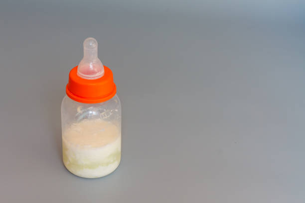 istock A bottle with a pacifier for feeding a baby with sour milk on a gray background. copy space 1323382727