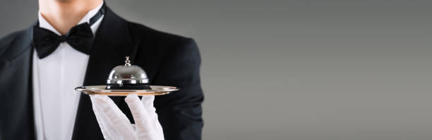 istock Midsection Of Waiter Holding Service Bell In Plate 1323382796