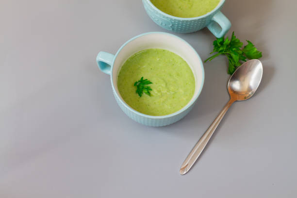 istock Green cabbage broccoli soup in plates decorated with parsley leaves 1323382967