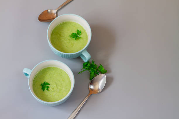 istock Green cabbage broccoli soup in plates decorated with parsley leaves 1323382970