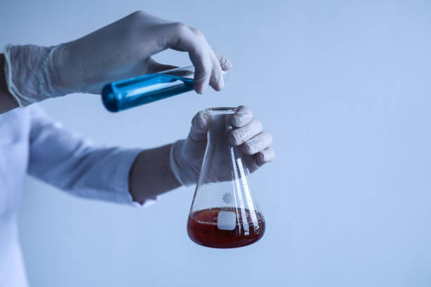 istock Chemist Experimenting With Red And Blue Liquids In The Laboratory 1323387600