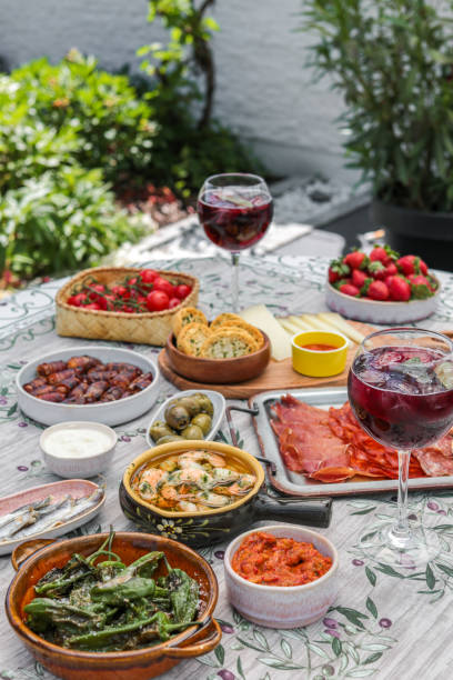 Summer Table with variety of Spanish Tapas Food Plates and Sangria Summer Table with variety of Spanish Tapas Food Plates and Sangria spanish culture stock pictures, royalty-free photos & images