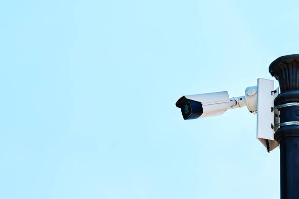 istock Security camera on a light pole on the street. CCTV surveillance security camera video equipment. Home security system concept. Safety system area control outdoor with copy space, 1323391299