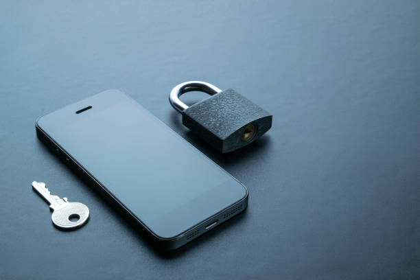 istock Mobile security. Modern space grey mobile phone with padlock, key on dark background. Identity theft and cyber security concept. 1323393361