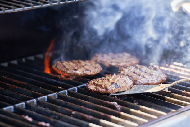 istock Cooking meat for burger on grill. Flame rising up from grid. 1323393592