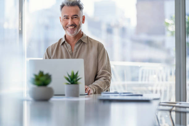 istock Mature businessman working at a desk on a laptop computer. 1323395120