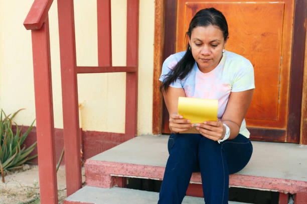 mujer leyendo sus notas fuera de casa - outdoors book reading accessibility fotografías e imágenes de stock