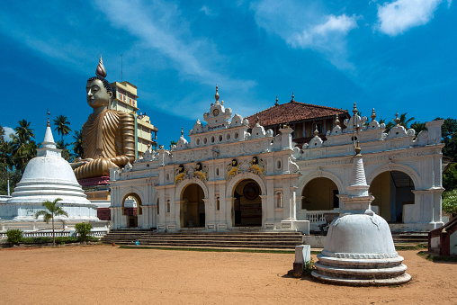 Dikwella, Wewurukannala Vihara Temple, Sri Lanka: entrance to the temple with the large buddha statue that dominates the surrounding space